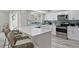 Well-lit kitchen showcasing white cabinets, stainless steel appliances, and a sleek island with seating at 6712 Jennifer Dr, Temple Terrace, FL 33617