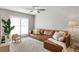 Comfortable living room showcases a plush brown sectional and natural light from the large window at 6712 Jennifer Dr, Temple Terrace, FL 33617