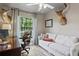 Spacious home office with a large window, a comfortable chair, a white couch, and unique deer head decor at 6712 Jennifer Dr, Temple Terrace, FL 33617