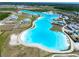 Aerial view of a neighborhood lagoon surrounded by sidewalks, common areas, and single-Gathering homes at 7486 Tuscan Bay Cir, Wesley Chapel, FL 33545