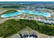 An aerial view showing a community lagoon bordered by new homes in a Primary planned community at 7486 Tuscan Bay Cir, Wesley Chapel, FL 33545