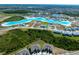 An aerial view showing a community lagoon bordered by new homes in a landscaped neighborhood at 7486 Tuscan Bay Cir, Wesley Chapel, FL 33545