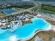 An aerial view showing a community lagoon with clubhouse surrounded by homes in a Primary planned community at 7486 Tuscan Bay Cir, Wesley Chapel, FL 33545