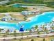 An aerial view showcases the lagoon featuring water inflatables, beach access, and white sand beaches at 7486 Tuscan Bay Cir, Wesley Chapel, FL 33545