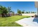 Spacious backyard featuring green grass, trees, with a concrete patio and sturdy fence surround at 7486 Tuscan Bay Cir, Wesley Chapel, FL 33545
