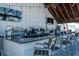 Bar featuring granite countertops, multiple TVs and hanging string lights at 7486 Tuscan Bay Cir, Wesley Chapel, FL 33545