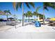 View of a sandy beach with lounge chairs and umbrellas at a community lagoon at 7486 Tuscan Bay Cir, Wesley Chapel, FL 33545