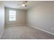 Carpeted bedroom features a ceiling fan and a window that provides natural light at 7486 Tuscan Bay Cir, Wesley Chapel, FL 33545