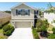 Inviting two-story home with a manicured lawn, neutral exterior, and attached two-car garage at 7486 Tuscan Bay Cir, Wesley Chapel, FL 33545