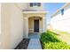 Inviting entryway features a covered porch, dark-stained front door and green bushes at 7486 Tuscan Bay Cir, Wesley Chapel, FL 33545