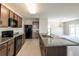 Modern kitchen featuring stainless steel appliances, granite countertops, and open layout to living area at 7486 Tuscan Bay Cir, Wesley Chapel, FL 33545
