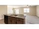 Modern kitchen with granite island open to the living area with backyard view at 7486 Tuscan Bay Cir, Wesley Chapel, FL 33545