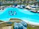 Aerial view of a large lagoon with a waterpark, sandy beach, and multiple resort-style amenities at 7486 Tuscan Bay Cir, Wesley Chapel, FL 33545