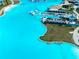 An aerial view of a lagoon with a swim-up bar, seating areas, a beach, and an inflatable obstacle course at 7486 Tuscan Bay Cir, Wesley Chapel, FL 33545