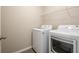 Bright laundry room featuring modern appliances and shelving for storage at 7486 Tuscan Bay Cir, Wesley Chapel, FL 33545