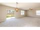 Well lit living room featuring neutral walls and access to backyard through sliding glass doors at 7486 Tuscan Bay Cir, Wesley Chapel, FL 33545