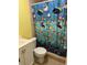 Cozy bathroom with a toilet, sink, cabinet, and colorful shower curtain at 7503 N Howard Ave, Tampa, FL 33604