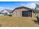 Back exterior view of home featuring a screened-in patio and well-kept yard at 8704 Sandy Plains Dr, Riverview, FL 33578