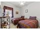 Bright bedroom with two twin beds, matching bedspreads, and colorful curtains at 8704 Sandy Plains Dr, Riverview, FL 33578