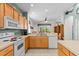 Modern kitchen with white appliances, light-colored cabinets, and tile flooring at 8704 Sandy Plains Dr, Riverview, FL 33578