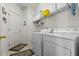 Bright laundry room featuring a white washer and dryer and shelving at 8704 Sandy Plains Dr, Riverview, FL 33578