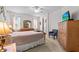 Bright main bedroom with a ceiling fan, TV, large dresser, and neutral carpet at 8704 Sandy Plains Dr, Riverview, FL 33578