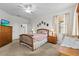 Sunny bedroom with ceiling fan, carpeted floors, and window overlooking the green outdoors at 8704 Sandy Plains Dr, Riverview, FL 33578