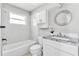 Bathroom with tub, toilet, granite vanity and decorated circular mirror at 907 Tyner St, Plant City, FL 33563