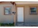 Close-up view of the front door with white paint, flanked by windows and the house number at 907 Tyner St, Plant City, FL 33563
