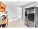 Neutral kitchen features stainless steel refrigerator, double sinks, tile floor, and wooden cabinets at 907 Tyner St, Plant City, FL 33563