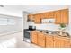 Kitchen featuring wooden cabinets, a double-bowl stainless steel sink, and an electric range at 907 Tyner St, Plant City, FL 33563