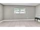 Bright living room with tiled flooring, neutral walls, and a bench beneath a window at 907 Tyner St, Plant City, FL 33563