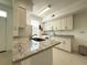 Bright kitchen featuring granite countertops, white cabinetry, and stainless-steel appliances at 9650 Lake Chase Island Way # 9650, Tampa, FL 33626