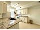 Bright kitchen featuring granite countertops, white cabinetry, and stainless-steel appliances at 9650 Lake Chase Island Way # 9650, Tampa, FL 33626