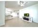 Bright living room featuring tile floors, ceiling fan, and a modern TV stand, with kitchen access at 9650 Lake Chase Island Way # 9650, Tampa, FL 33626