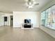 Bright living room featuring tile floors, ceiling fan, and a modern TV stand, connecting seamlessly to other spaces at 9650 Lake Chase Island Way # 9650, Tampa, FL 33626
