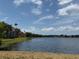 Scenic view of a tranquil pond surrounded by lush greenery and vibrant townhomes at 9650 Lake Chase Island Way # 9650, Tampa, FL 33626