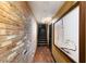 Hallway features a brick accent wall and hardwood floors at 107 Athenian Way, Tarpon Springs, FL 34689