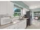 Bright kitchen with white cabinetry, stainless steel appliances, and natural light streaming in from the adjacent window at 10828 99Th Pl, Seminole, FL 33772
