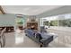 Airy living room with a brick fireplace, views to the outside, and sleek Terrazzo flooring at 10828 99Th Pl, Seminole, FL 33772