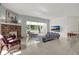 Bright living room with a cozy fireplace, large windows offering scenic views, and comfortable seating arrangements at 10828 99Th Pl, Seminole, FL 33772
