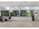 Bright sunroom filled with natural light from large windows, showcasing views of lush greenery and a tranquil pond at 10828 99Th Pl, Seminole, FL 33772