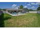Expansive backyard featuring a kidney-shaped pool, lounge chairs, lush green lawn, and mature trees at 1104 Northridge Dr, Palm Harbor, FL 34683