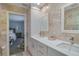Bathroom with dual sinks, white cabinets, decorative mirrors, and tile flooring at 1104 Northridge Dr, Palm Harbor, FL 34683