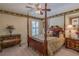 Traditional primary bedroom with a four-poster bed, ceiling fan, and period furnishings at 1104 Northridge Dr, Palm Harbor, FL 34683