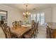 Formal dining area featuring a chandelier, wood table and chairs, shuttered windows, and elegant decor at 1104 Northridge Dr, Palm Harbor, FL 34683