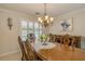 Dining room boasts an ornate table set, complemented by shuttered windows with a pool view, enhanced by a classic chandelier at 1104 Northridge Dr, Palm Harbor, FL 34683