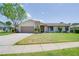 Charming single-story home with stone accents, a well-manicured lawn and an attached two car garage at 1104 Northridge Dr, Palm Harbor, FL 34683