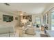 Bright living room showcasing modern sofas, neutral walls, and a ceiling fan, with views of the outdoor pool at 1104 Northridge Dr, Palm Harbor, FL 34683