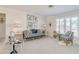 Elegant living room with unique chairs, striped sofa, decorative mirrors, and ample natural light at 1104 Northridge Dr, Palm Harbor, FL 34683